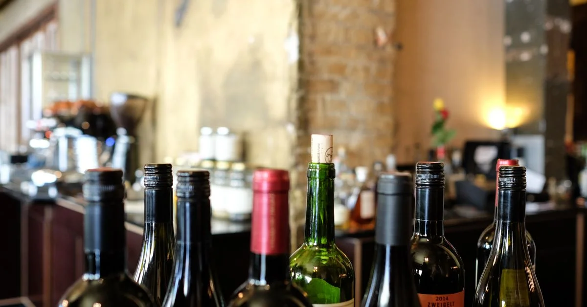 Une sélection de bouteilles de vin avec des bouchons sur le comptoir d'un bar de restaurant, idéale pour les thèmes gastronomiques.