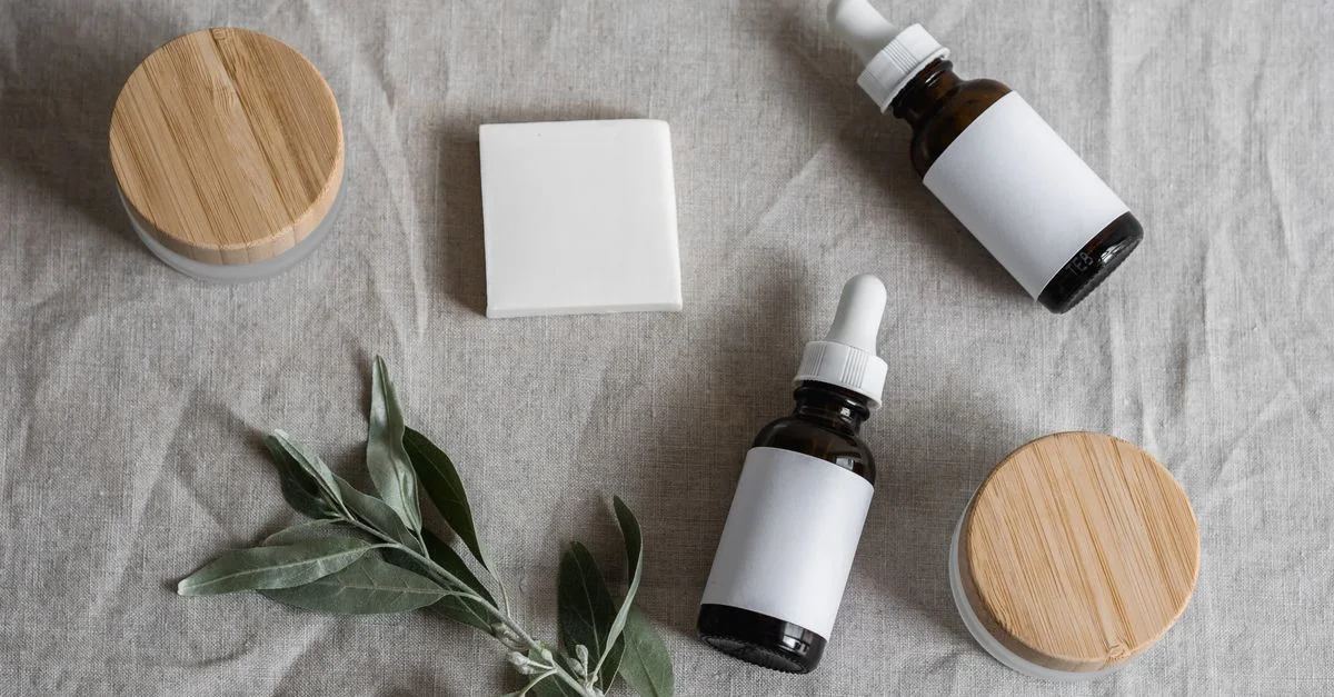 Vue de dessus de produits de soin de la peau avec un thème naturel, comprenant des flacons, pots et une plante sur un tissu en lin.