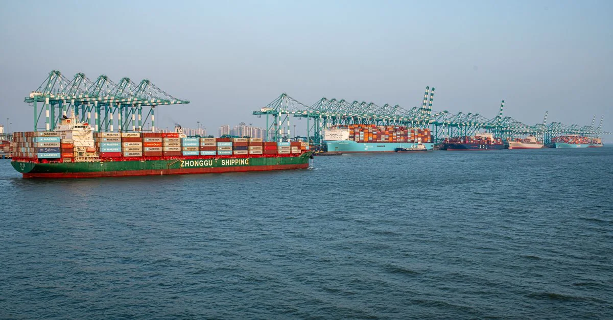 Un port maritime animé, où l'on observe des porte-conteneurs et des opérations de grue sous un ciel dégagé.