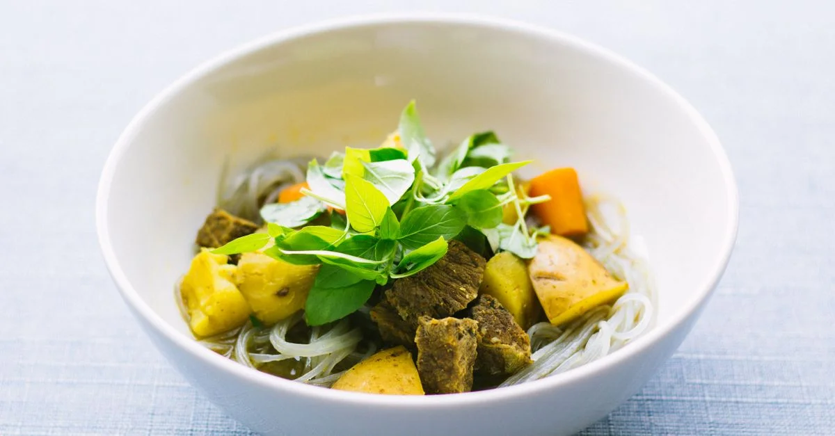 Un bol savoureux de soupe de nouilles vietnamienne garni d'herbes fraîches et de légumes.