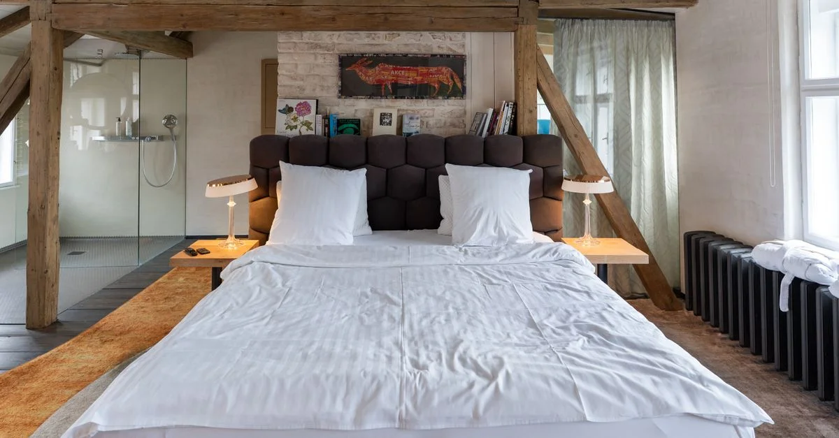 Une chambre cosy à Krumau, avec poutres apparentes et décoration moderne, mêlant styles rustique et contemporain.