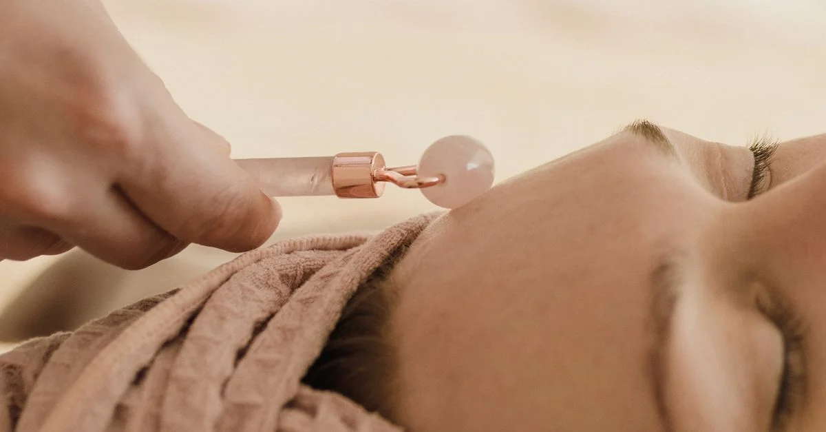 Gros plan sur un massage au rouleau en jade lors d'un soin du visage, favorisant la relaxation et les soins de la peau.