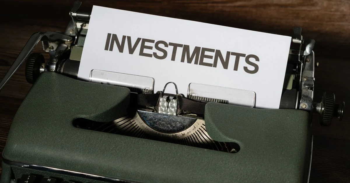 Gros plan d'une machine à écrire vintage avec un papier étiqueté 'INVESTISSEMENTS'.